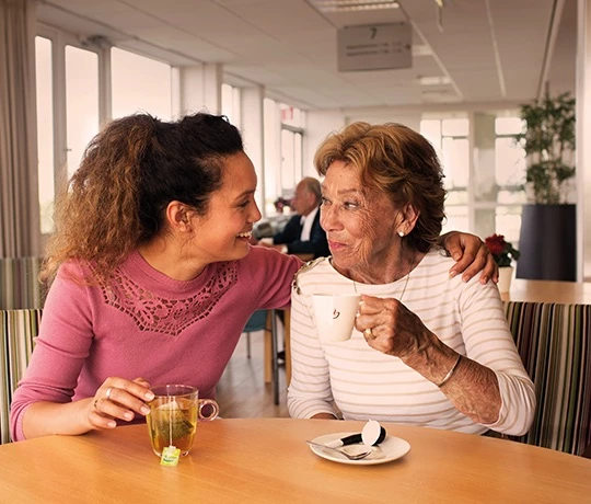 Zwei Frauen sitzen zusammen beim Kaffee von Jacobs Professional.