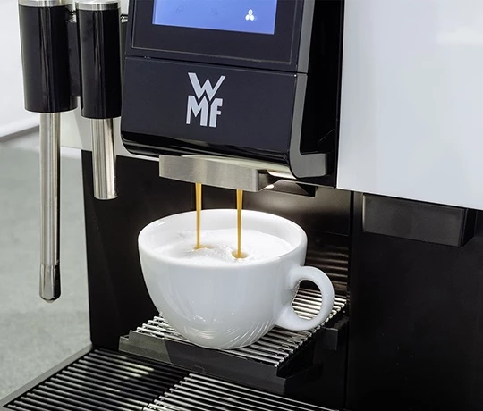 Eine Tasse Kaffee wird gerade an einem WMF1100 Kaffeevollautomaten von Jacobs Professional gemacht.
