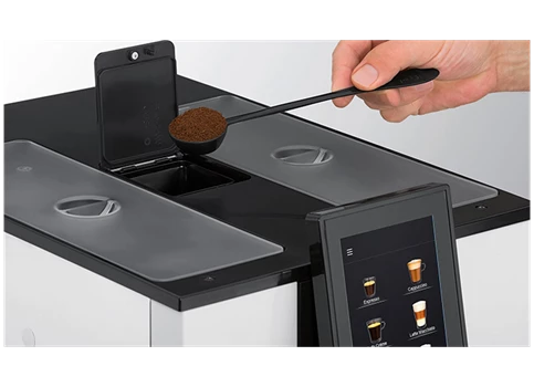 Ein WMF1100 Kaffeevollautomat von Jacobs Professional wird gerade aufgefüllt.