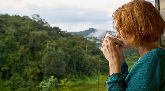 Abbildung einer jungen Frau, die eine Tasse Kaffee trinkt.