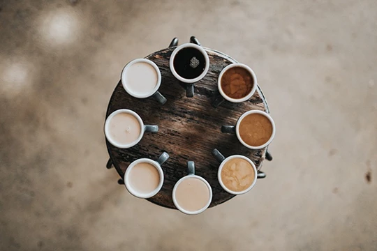 Verschiedene Kaffeesorten sind im Kreis auf einem Tablett angeordnet.