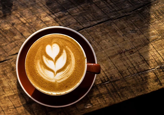 Abbildung einer Kaffeetasse auf einem Holztisch.
