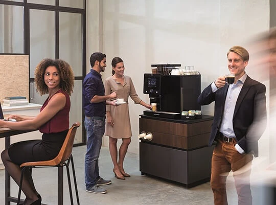 Mehrere Mitarbeiter im Büro trinken Kaffee und Tee von Jacobs Professional