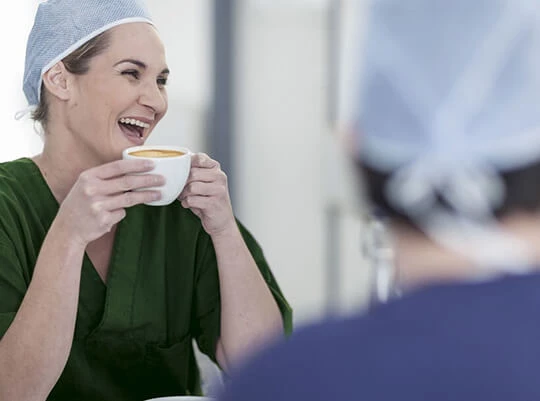 Eine Frau trinkt eine Tasse Jacobs Kaffee auf der Arbeit