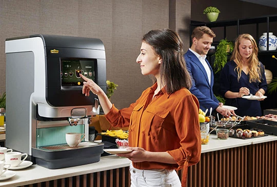 Eine Frau holt sich gerade einen Kaffee an der Jacobs Professional Cafitesse Kaffeemaschine