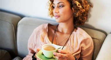 Frau genießt eine Tasse Kaffee von Jacobs Professional