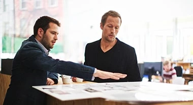 Zwei Männer unterhalten sich und trinken Jacobs Professional Kaffee