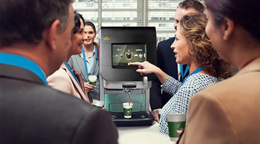 Menschen stehen vor Cafitesse Excellence Touch Kaffeemaschine