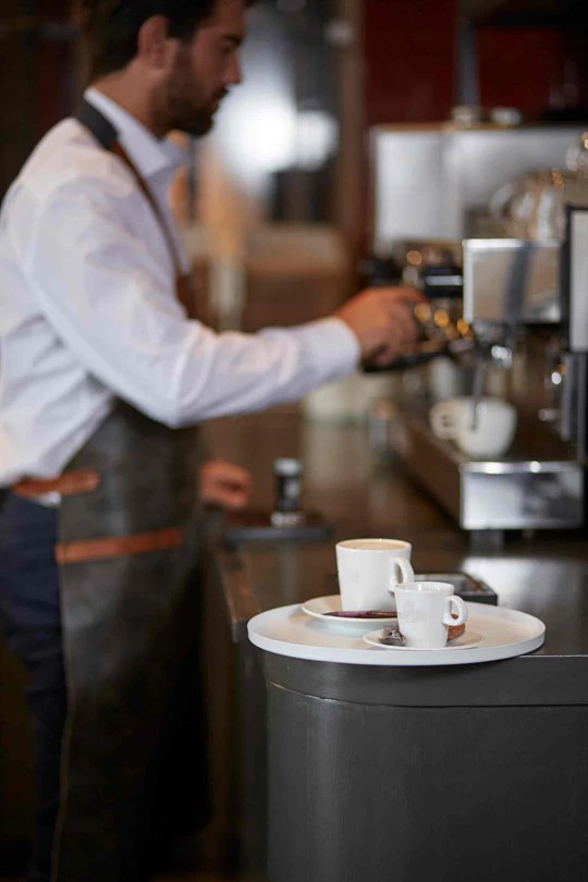 Ein Barista bereitet Kaffee von Jacobs Professional im Restaurant zu