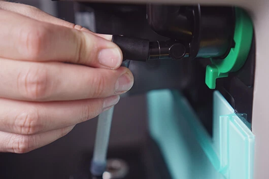 Der dosierschlauch der Cafitesse Excellence Compact Touch wird getrennt.