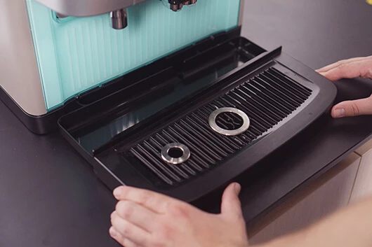 Tropfschale mit Gitter in die Cafitesse Excellence Compact Touch einsetzen.