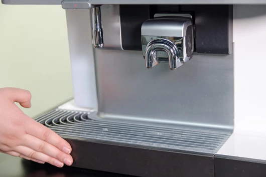 Die Tropfschale der Promesso Kaffeemaschine von Jacobs Professional wird eingesetzt.