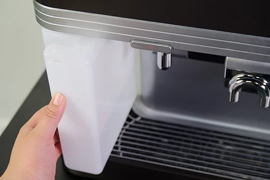 Der Wassertank der Promesso Kaffeemaschine von Jacobs Professional wird entfernt.