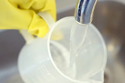 Wasser wird zur L'OR Promesso Entkalkungslösung gegeben.